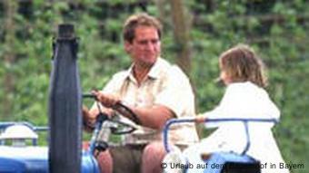 Landwirt mit Kind auf dem Traktor