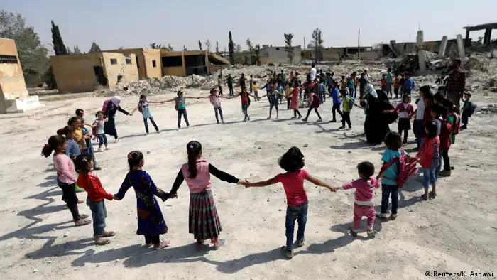 Des enfants syriens jouent devant les ruines de leur école à al-Saflaniyeh, près d'Alep