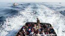 A Libyan coast guardsman stands on a boat during the rescue of 147 illegal immigrants attempting to reach Europe off the coastal town of Zawiyah, 45 kilometres west of the capital Tripoli, on June 27, 2017.
More than 8,000 migrants have been rescued in waters off Libya during the past 48 hours in difficult weather conditions, Italy's coastguard said on June 27, 2017. / AFP PHOTO / Taha JAWASHI (Photo credit should read TAHA JAWASHI/AFP/Getty Images)