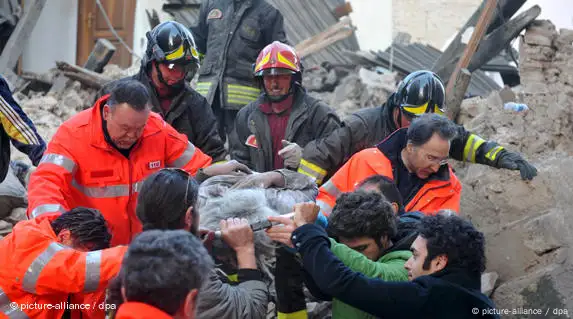 Feuerwehrleute bergen ein Todesopfer des Erdbebens aus dem Trümmerfeld (Foto: dpa)