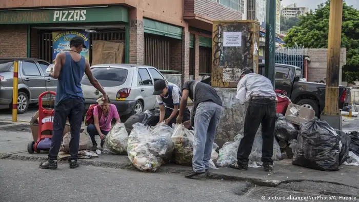 Menschen in Caracas, Venezuela, durchsuchen Müllsäcke nach Lebensmitteln (picture-alliance/NurPhoto/A. Fuente)