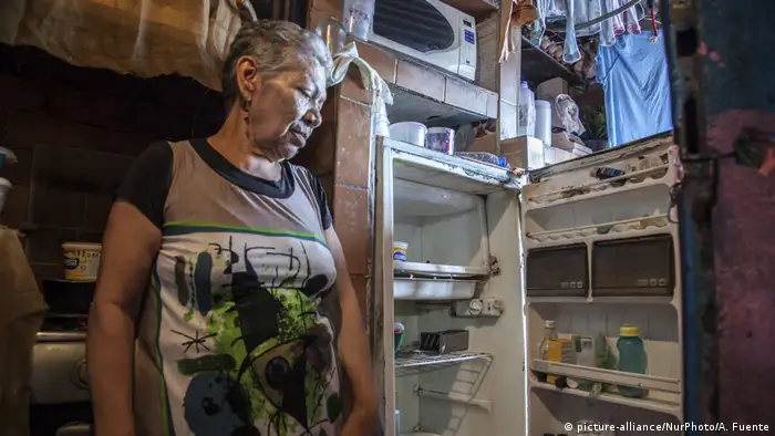 Eine Frau in Caracas vor einem fast leeren Kühlschrank (picture-alliance/NurPhoto/A. Fuente)