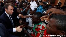 French President Emmanuel Macron shakes hands with people in the crowd as he leaves the Ouagadougou University, in Ouagadougou, Burkina Faso November 28, 2017. REUTERS/Philippe Wojazer