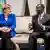 German Chancellor Angela Merkel sits on a sofa talking with Ivory Coast President Alassane Ouattara 