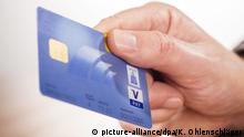 Nahaufnahme einer Hand mit Girocard der Postbank und V Pay Logo | Verwendung weltweit