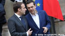 Greek Prime Minister Alexis Tsipras (R) speaks with French President Emmanuel Macron (L) as he leaves the Elysee Palace after a meeting on November 24, 2017 in Paris. / AFP PHOTO / ludovic MARIN (Photo credit should read LUDOVIC MARIN/AFP/Getty Images)