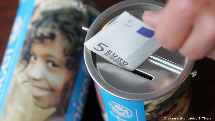 money being put into a charity tin