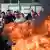 Fire is set as workers protest outside Teva headquarters in Jerusalem.