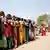 Wartende Menschen vor einem Wahlbüro in Indien