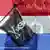 A skull-and-crossbones pirate flag against a background of the Dutch flag