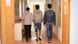 Young refugees walk in a hallway, backs to the camera Young refugees walk in a hallway, backs to the camera