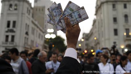 A protester holds up fake money during an anti-corruption march in Lima, Peru, in December 2017