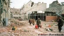 19.11.1991 - Menschen gehen am 19.11.1991 einen zerstörten Straßenzug in der Stadt Vukovar entlang. Die dreimonatigen heftigen Kämpfe um die kroatische Stadt Vukovar wurden am 19. November 1991 mit der bedingungslosen Kapitulation der kroatischen Verbände beendet. (zu dpa «Nach dem Krieg ist vor dem Krieg: Schulbücher hetzen Kinder auf» vom 21.12.2017) Foto: epa/afp/dpa +++(c) dpa - Bildfunk+++ | Verwendung weltweit