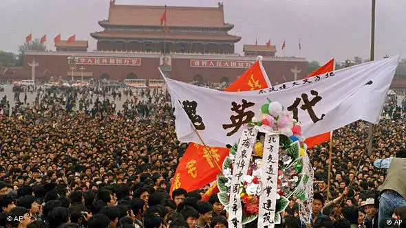 A funeral wreath, banner, and red flags make their way through a sea of people on Wednesday, April 19, 1989 in Beijing’s Tiananmen Square proceeding towards martyrs monument where thousands have gathered to eulogize late party chief Hu Yaobang. (AP Photo/Mark Avery)