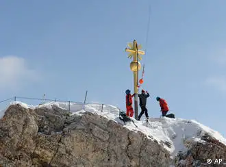 Arbeiter befestigen das frisch restaurierte Gipfelkreuz auf der Zugspitze (Foto: AP)