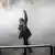 Mulher levanta o braço em meio a nuvem de gás lacrimogêneo durante protesto contra o governo em Teerã