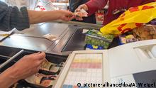 ARCHIV - An einer Supermarktkasse in einem Lebensmittelmarkt in Straubing (Bayern) wird am 16.01.2015 kassiert. Foto: Armin Weigel/dpa (zu dpa Steigende Preise - ein Grund zum Jubeln für Verbraucher? vom 13.10.2016) +++(c) dpa - Bildfunk+++ | Verwendung weltweit