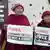Two exiled Tibetan nuns hold placards demanding the release of Tashi Wangchuk