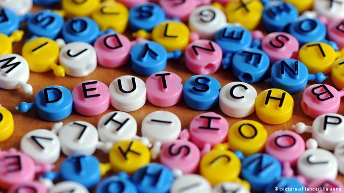 Das Wort Deutsch liegt aus einzelnen Buchstaben zusammengesetzt mit weiteren Buchstaben auf einem Tisch,