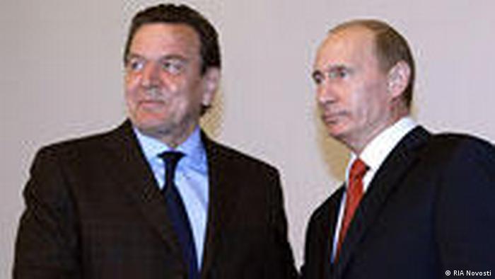 Former German Chancellor Gerhard Schröder shakes hands with Russian President Vladimir Putin in Moscow