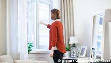 ILLUSTRATION - Eine junge Frau oeffnet am 28.10.2016 in einer Wohnung in Hamburg die Fenster, um das Wohnzimmer zu lueften (gestellte Szene). Foto: Christin Klose | Verwendung weltweit