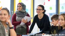 Marwa Sulaiman (2.v.l.) und Shogine Kamoyan (3.v.r.) hospitieren am 12.12.2017 an der Gesamtschule Rosenhöhe in Bielefeld (Nordrhein Westfalen) beim Matheunterricht. Die beiden Lehrerinnen aus Syrien und Armenien hospitieren an diesem Mittwoch an der Gesamtschule Rosenhöhe in Bielefeld. Sie sind zwei von 25 Teilnehmern eines in NRW bislang einzigartigen Modellprojekts. Das Programm «Lehrkräfte Plus» der Universität Bielefeld richtet sich an Flüchtlinge, die sehr gut Deutsch sprechen und in ihrer Heimat als Lehrer gearbeitet haben. (zu dpa: Zurück zur Schule: Uni Bielefeld bildet Flüchtlinge zu Lehrern aus) Foto: Oliver Krato/dpa +++(c) dpa - Bildfunk+++ | Verwendung weltweit