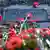 Red carnations lie around a memorial plaque for Karl Liebknecht