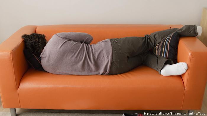 man asleep on orange sofa (picture-alliance/Bildagentur-online/Tetra)