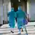 Two masked doctors rush toward a door at an airport