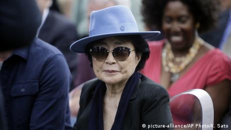 Yoko Ono mit blauem Hut und Sonnenbrille.