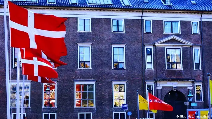 Denmark, Copenhagen, brick building with Danish flags (Niaz Moammadkhani)