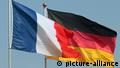Flaggen Deutschlands und Frankreichs wehen einträchtig vor blauem Himmel...