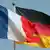 Flaggen Deutschlands und Frankreichs wehen einträchtig vor blauem Himmel...