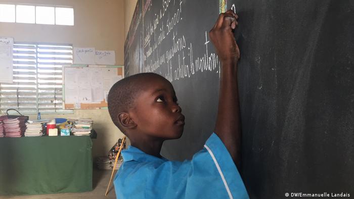 Ein senegalesischer Junge schreibt an eine Tafel