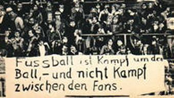 Fans hold a banner that says football is a fight for the ball, not a fight between fans