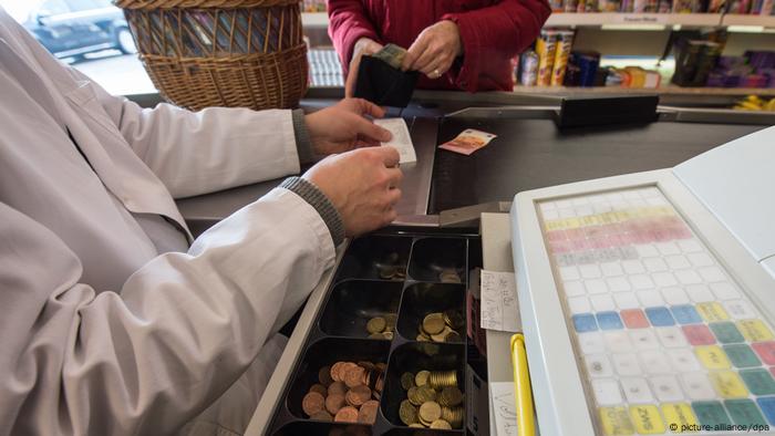 Someone pays at a supermarket checkout.  (picture alliance/dpa)