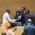 Alpha Conde and Kagame shake hands surrounded by other AU functionaries
