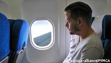 Male passenger looking out the window on commercial flight |