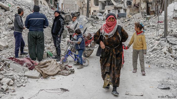 A group of people standing next to a destroyed building
