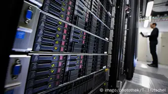 A man stands in front of server racks