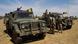 Mali soldiers stand next to military trucks Mali soldiers stand next to military trucks