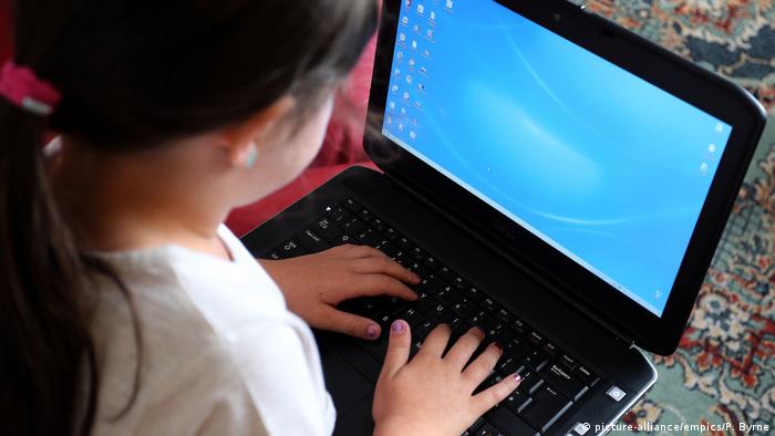Foto simbólica de una niña frente a una computadora.