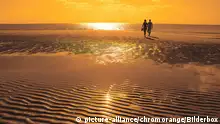 Paar am Strand bei Sonnenuntergang | Verwendung weltweit