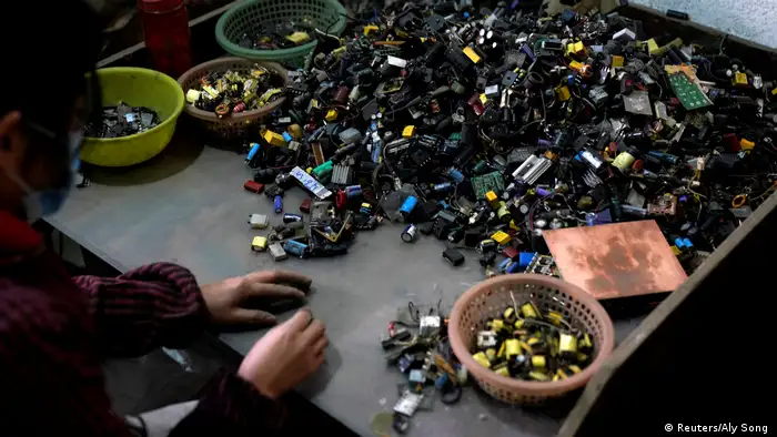 Photo: A person dismantling electronics (Source: Reuters/Aly Song )