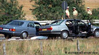 Polizisten stehen auf der Autobahn. Der Fluchtwagen der Geiselnehmer (rechts) wurde von dem Mercedes der Polizei (links) auf der Autobahn 3 bei Bad Honnef gestoppt.