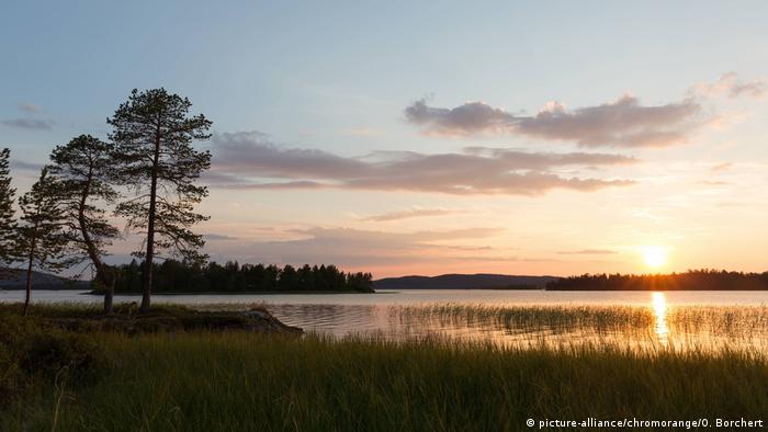 Finland: Midnight sun above a lake in the summer (picture-alliance/chromorange/O. Borchert)