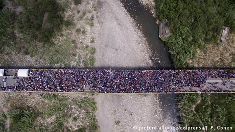 People flood over a bridge as vewed from above (picture alliance/colprensa/J. P. Cohen)