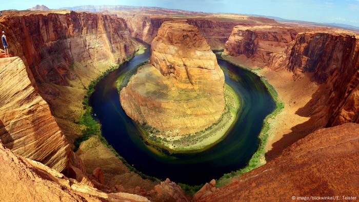 A deep canyon, at the bottom of which a river runs around a large rock 