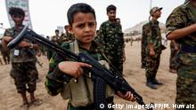 A Yemeni boy poses with a Kalashnikov assault rifle during a gathering of newly-recruited Huthi fighters in the capital Sanaa, to mobilize more fighters to battlefronts in the war against pro-government forces in several Yemeni cities, on July 16, 2017. / AFP PHOTO / Mohammed HUWAIS (Photo credit should read MOHAMMED HUWAIS/AFP/Getty Images)