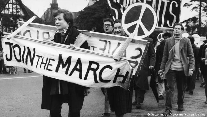 Demonstranten tragen Transparent mit den Worten Join the March und Schilder mit Peace-Zeichen. Foto in Schwarz-Weiss. (Getty Images/Keystone/Hulton Archive)